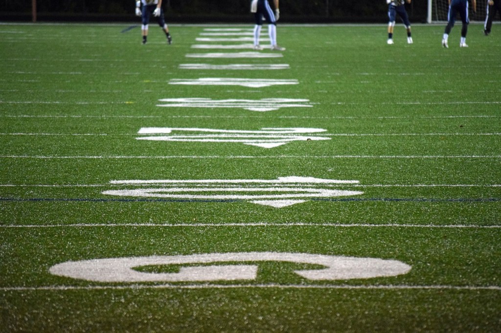 Football players line up on an American football field.